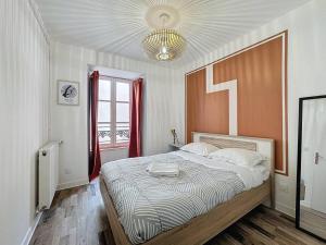 クレルモン・フェランにあるCharmant appartement Montferrand 5 persの大きなベッドと窓のある寝室