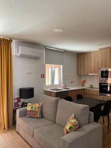 Una sala de estar con un sofá y una cocina. en Casa Nêspera, en Lisboa