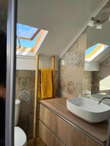 Un baño con lavabo, inodoro y ventana. en Casa Nêspera, en Lisboa