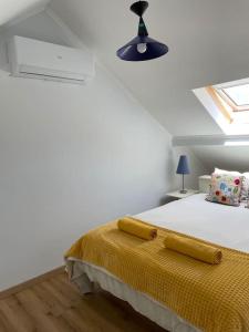 Un dormitorio blanco con una cama con una manta amarilla. en Casa Nêspera, en Lisboa