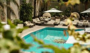 a swimming pool with chairs and tables and umbrellas at Holiday Inn Rosario by IHG in Rosario