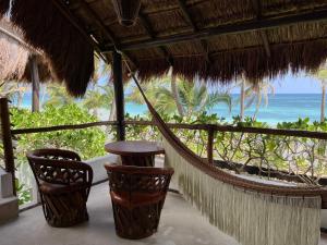 a hammock in a resort with a view of the ocean at The Beach Tulum Hotel in Tulum