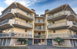 an apartment building with balconies and palm trees at Lovely Apartment In Pietra Ligure in Pietra Ligure