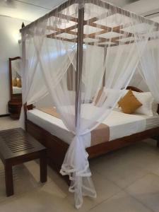 Postel nebo postele na pokoji v ubytování Singapore Bungalow Galle