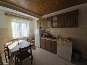 a kitchen with a table and a white refrigerator at Rural Household Baltic in Mojkovac
