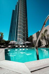 a swimming pool in front of a tall building at Holiday Inn Rosario by IHG in Rosario