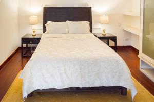 ein Schlafzimmer mit einem großen Bett mit zwei Nachttischen in der Unterkunft Best Location - Unique And Charming Loft in Panama-Stadt