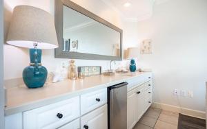 a bathroom with a vanity with a blue vase and a mirror at Phoenix on the Bay 1414 condo in Orange Beach