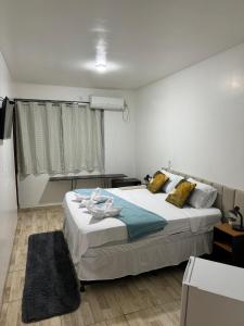 a bedroom with a large bed and a window at Pousada Villa Carolina in Carolina