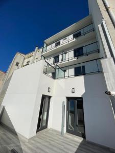 a white building with large windows and a blue sky at Brisarte in Arteixo