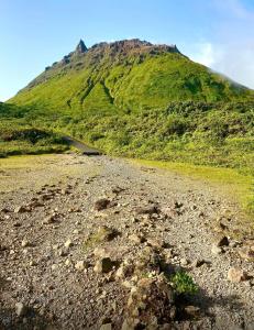 a dirt road with a mountain in the background at Au pied de la Soufrière in Saint-Claude