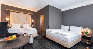 Postel nebo postele na pokoji v ubytování PLAZA Premium Parkhotel Norderstedt