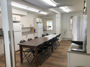 贾斯珀Jasper East Hostel - Near Jasper National Park East Gate Entrance的一间带桌子和椅子的大厨房