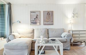 a living room with a couch and a table at 3 Bedroom Amazing Home In Hornbæk in Hornbæk