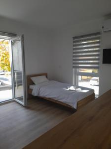 a bedroom with a bed and a large window at Phoenix Apartments in Prilep