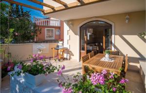 an outdoor patio with a wooden table and flowers at 2 Bedroom Amazing Home In Sveti Vid in Sveti Vid-Miholjice