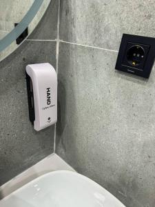 a white soap dispenser on a wall next to a toilet at DOSTYK Hotel in Zyryanovsk +18 photos