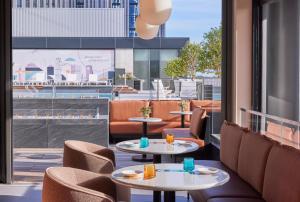 a restaurant with tables and chairs and a view of a city at Omni Boston Hotel at the Seaport in Boston