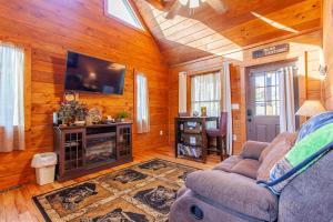 a living room with a couch and a tv at Cozy Cub at Deep Creek in Bryson City