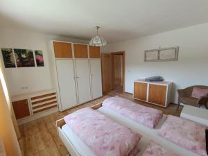 a bedroom with two beds and a cabinet at Ferienwohnung Marchnerhof in Terento