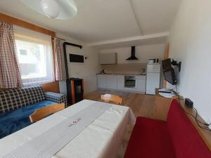 a living room with a white table and a kitchen at Ferienwohnung Marchnerhof in Terento