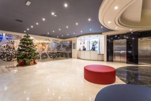 un hall avec un arbre de Noël et un tabouret rouge dans l'établissement Hotel Urban Dream Granada, à Grenade