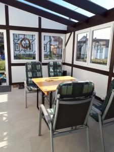 a table and chairs in a room with windows at Ferienhaus zum Rossbach in Biberschlag