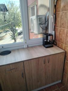 a kitchen with a counter with a microwave and a window at Garsoniera in Craiova