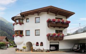 Biały budynek z skrzyniami kwiatowymi w obiekcie Stilvolle Ferienwohnung w mieście Sankt Anton am Arlberg