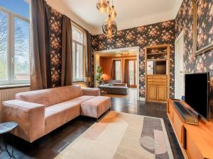 a living room with a couch and a tv at Vakantiehuis L'Antoniade in Flobecq