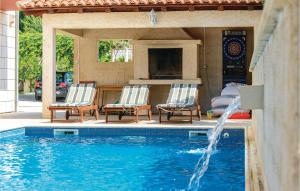two chairs and a swimming pool with a fireplace at Holiday Home Pinji Vi in Zaton