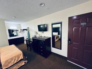 a hotel room with a bed and a desk with a mirror at Americas Best Value Inn Calimesa in Calimesa