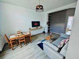 a living room with a couch and a table and a dining room at Celine Appart in Cormontreuil