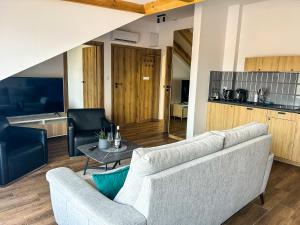 a living room with a couch and a table at Aquarius Stawy 10 in Grodzisk Mazowiecki