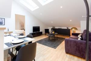 a living room with a couch and a table at Opus Reims in Reims