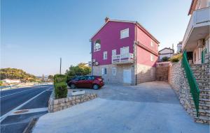 une voiture rouge garée devant une maison dans l'établissement Amazing Apartment In Mundanije, à Mundanije
