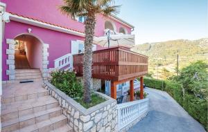une maison rose avec un balcon et un palmier dans l'établissement Amazing Apartment In Mundanije, à Mundanije 21 autres photos