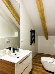 a bathroom with a white sink and a toilet at Aquarius Stawy 11 in Grodzisk Mazowiecki