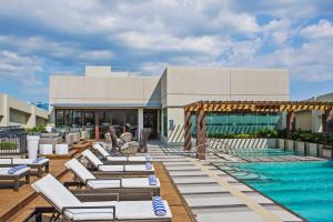 a resort with a swimming pool and lounge chairs at Holiday Inn & Suites Makati by IHG in Manila