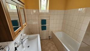 a bathroom with a tub and a sink at Apartmán v Kysuci in Kysucké Nové Mesto
