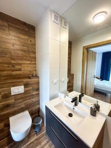a bathroom with a white sink and a toilet at Aquarius Stawy Walczewskiego 8 in Grodzisk Mazowiecki