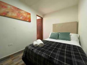 a bedroom with a bed with two slippers on it at Apartamento en Envigado al Sur de Medellin in Envigado
