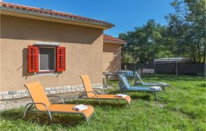 a group of chairs sitting in the grass next to a house at Holiday Home Kature Iv in Labin