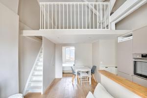 mała kuchnia i jadalnia z białymi ścianami i białymi schodami w obiekcie ST DOM Gauche - PARIS 7 - Best Place w Paryżu +8 zdjęć