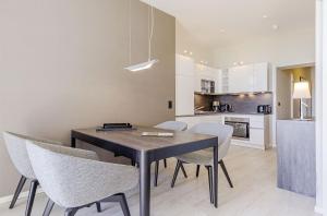 Una cocina y un comedor con mesa y sillas. en Moderne 5 Sterne Ferienwohnung Strandlilie, en Wustrow