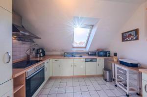 a kitchen with white cabinets and a window at Seeuferblick - Komfortable 2-Etagen-Wohnung für 4 Personen an der Müritz in Waren +12 photos