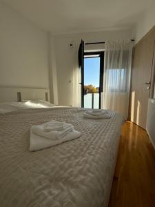 a white bed with two towels on top of it at Apartman Petrovic in Vranje
