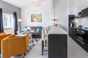 una cucina e un soggiorno con divano di Kietz-Idylle - Gemütliche Ferienwohnung mit Balkon und Zugang zu Wellnessbereich a Waren