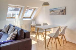 a living room with a couch and a table and chairs at Studio - Modernes Design nahe Müritzstrand & Wellness in Waren