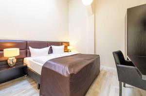 a hotel room with a bed and a chair at Kietz-Domizil mit Balkon & Müritzblick im historischen Speicher in Waren
